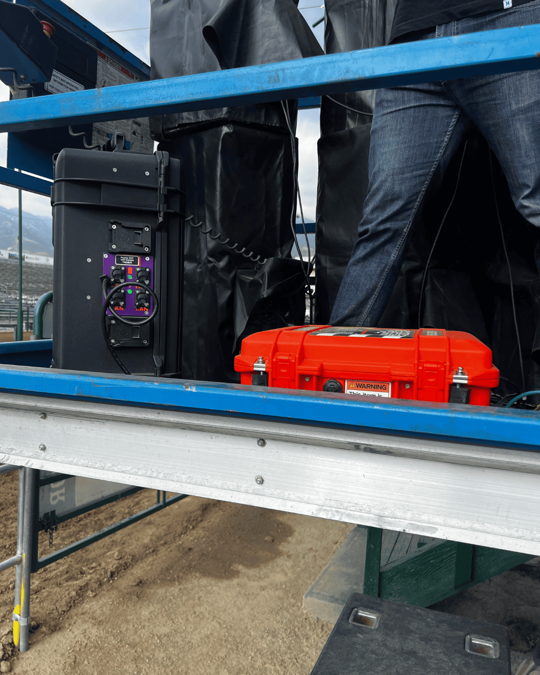Two PopUp WiFi units set up for providing live streaming internet on a scissor lift, with men's legs visible.