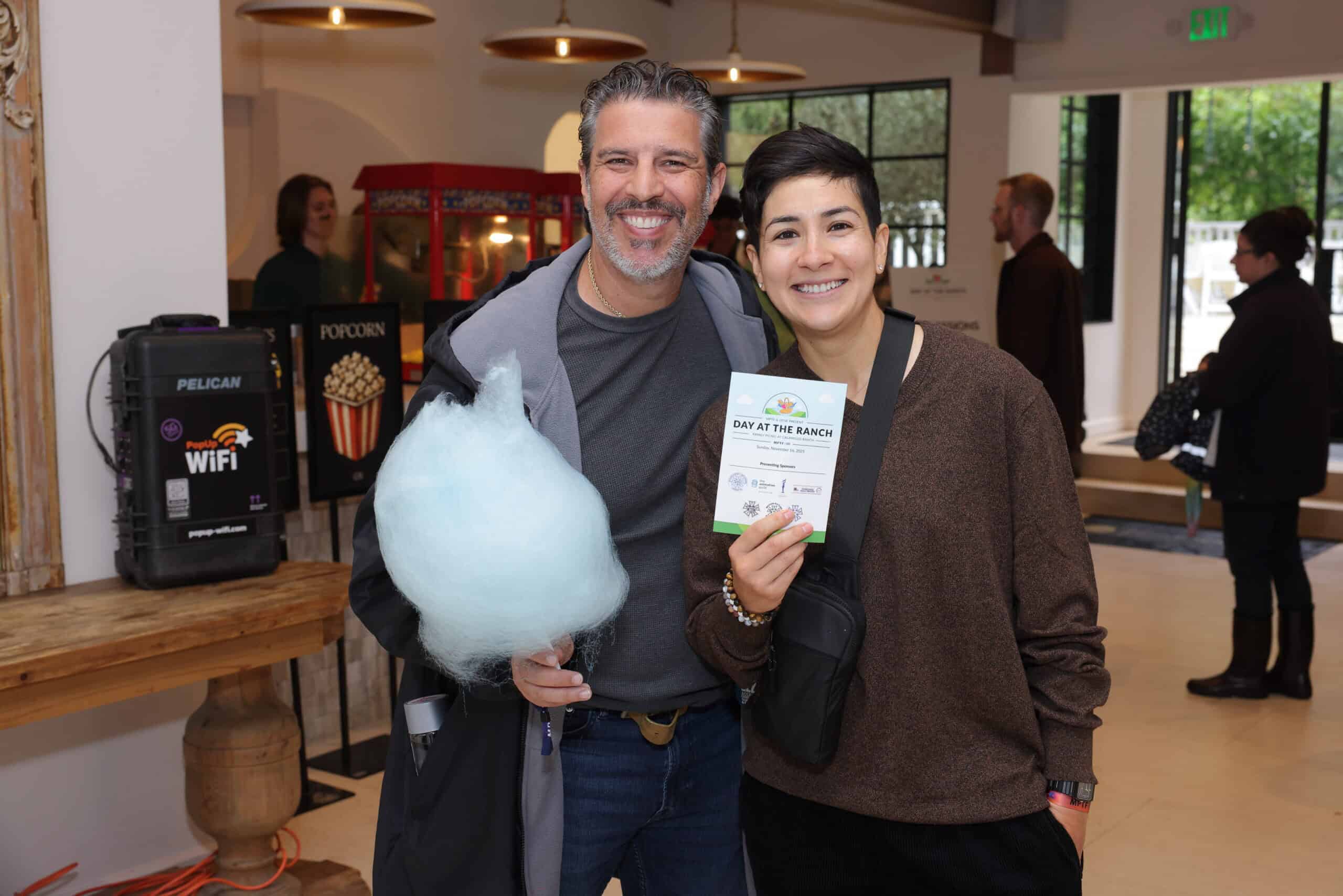 Event attendees showing their prizes from the silent auction with WiFi rental from PopUp WiFi in background in Malibu.