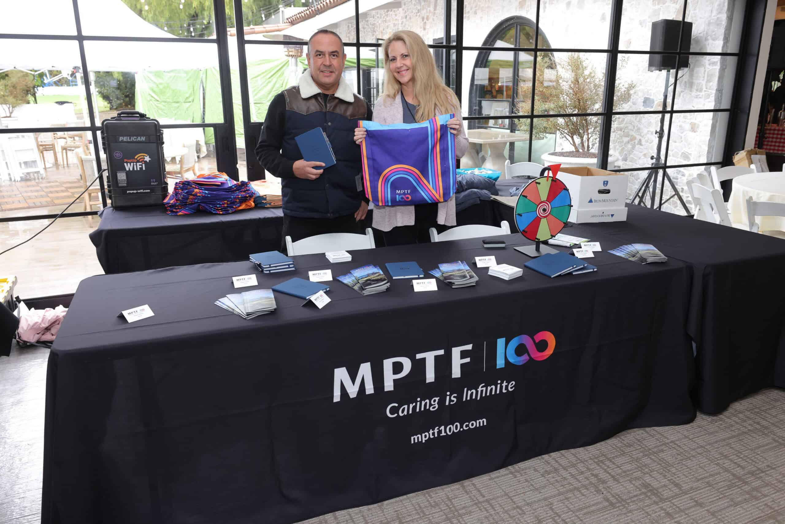 Trade show internet standing on a booth at Calamigos Ranch in California with stallholders holding up merchandise.