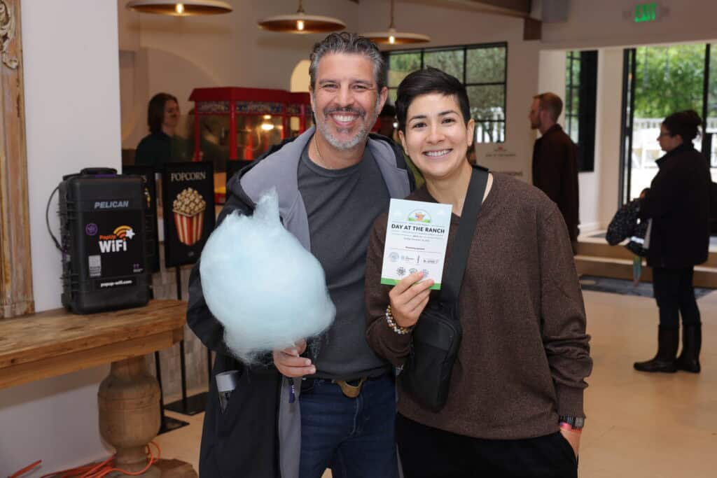 People at an event with PopUp WiFi bonded event internet for rent unit standing on a table in the background.