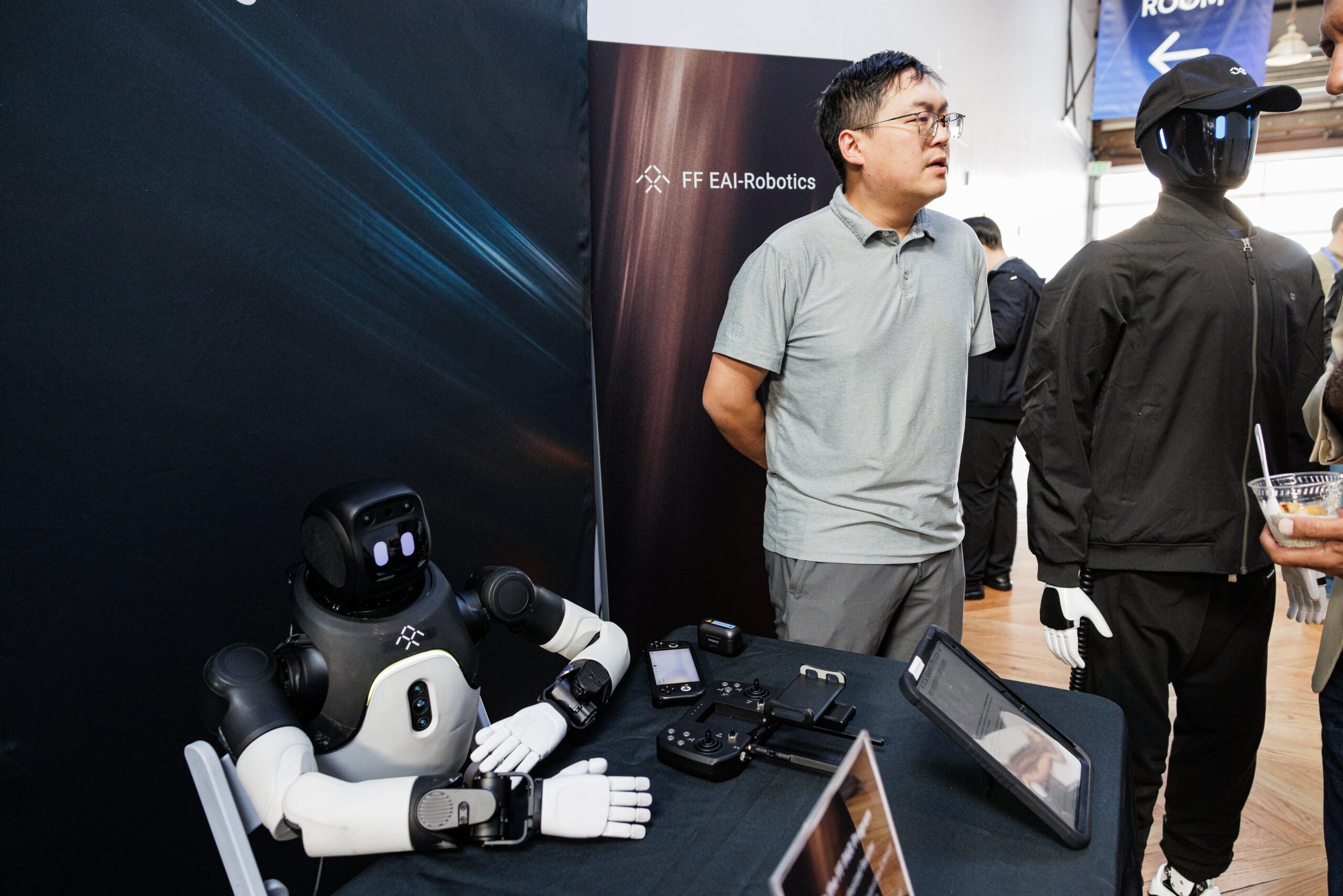 Two attendees viewing a "Meet Axel" robotics demo unit connected using PopUp WiFi for reliable conference internet during AUTONOMOUS 2026 networking hours