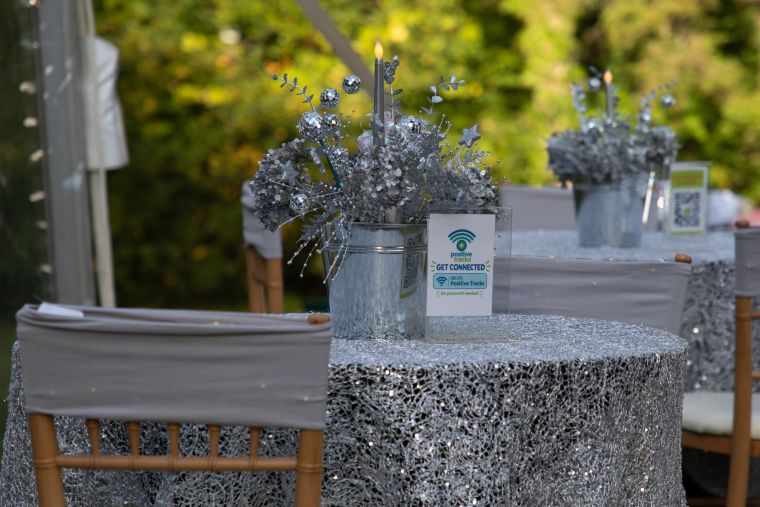A silver cocktail table centerpiece with a "Get Connected" guest WiFi sign and QR code at a New Hampshire fundraiser